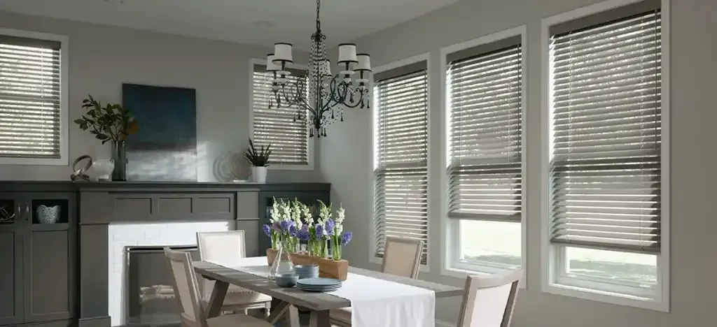 Dining room with a table set for a meal and wood blinds on the windows