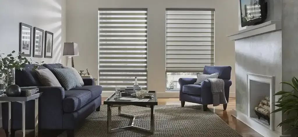 Living room with blue sofa, chair, fireplace, and window blinds.