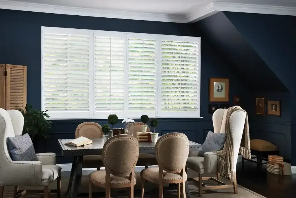 Dining room with white shutters and dark blue walls