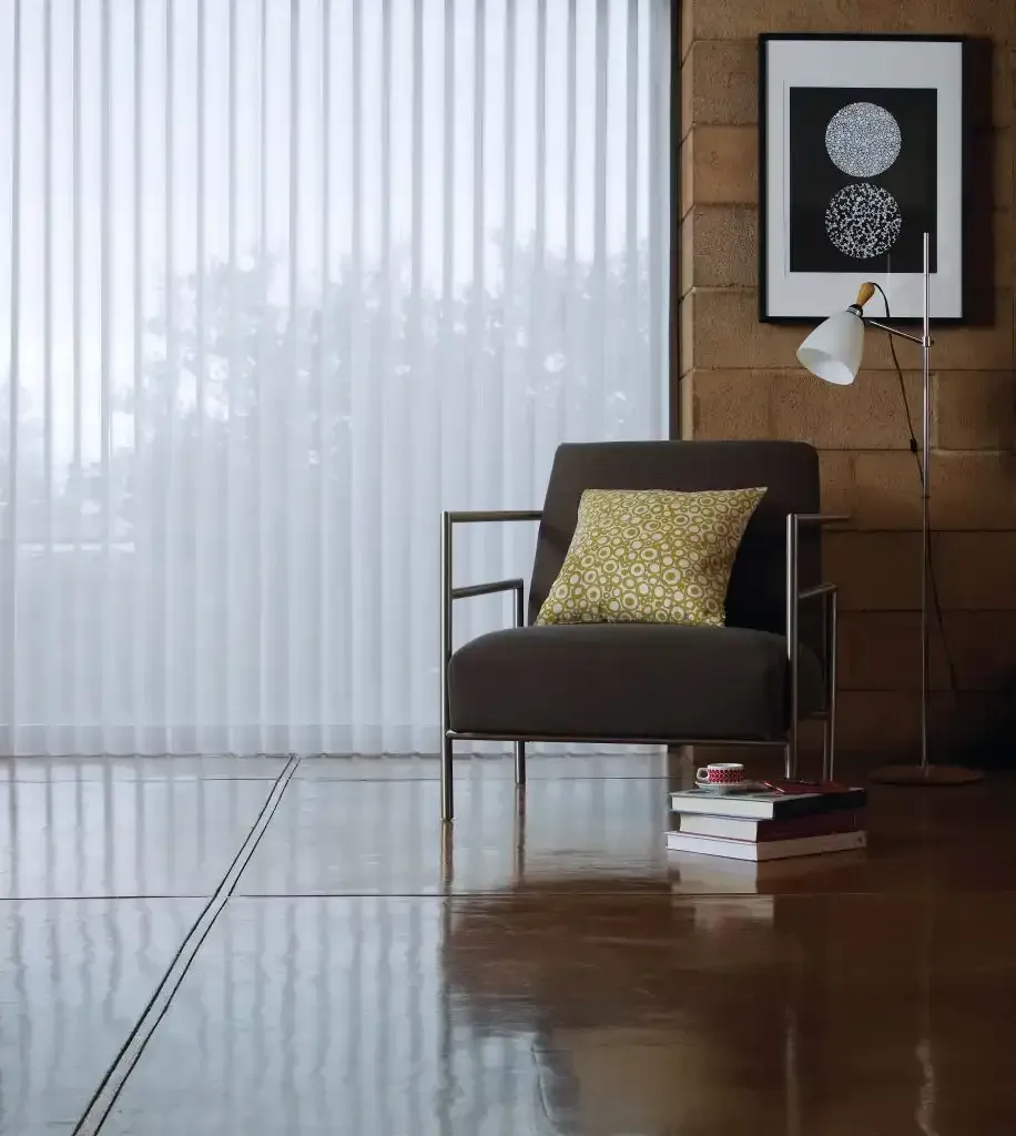 Living room with a chair, pillow, floor lamp, and vertical blinds on the window