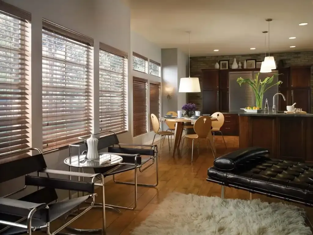 Living room with wooden floors, modern furniture, and large windows with blinds.