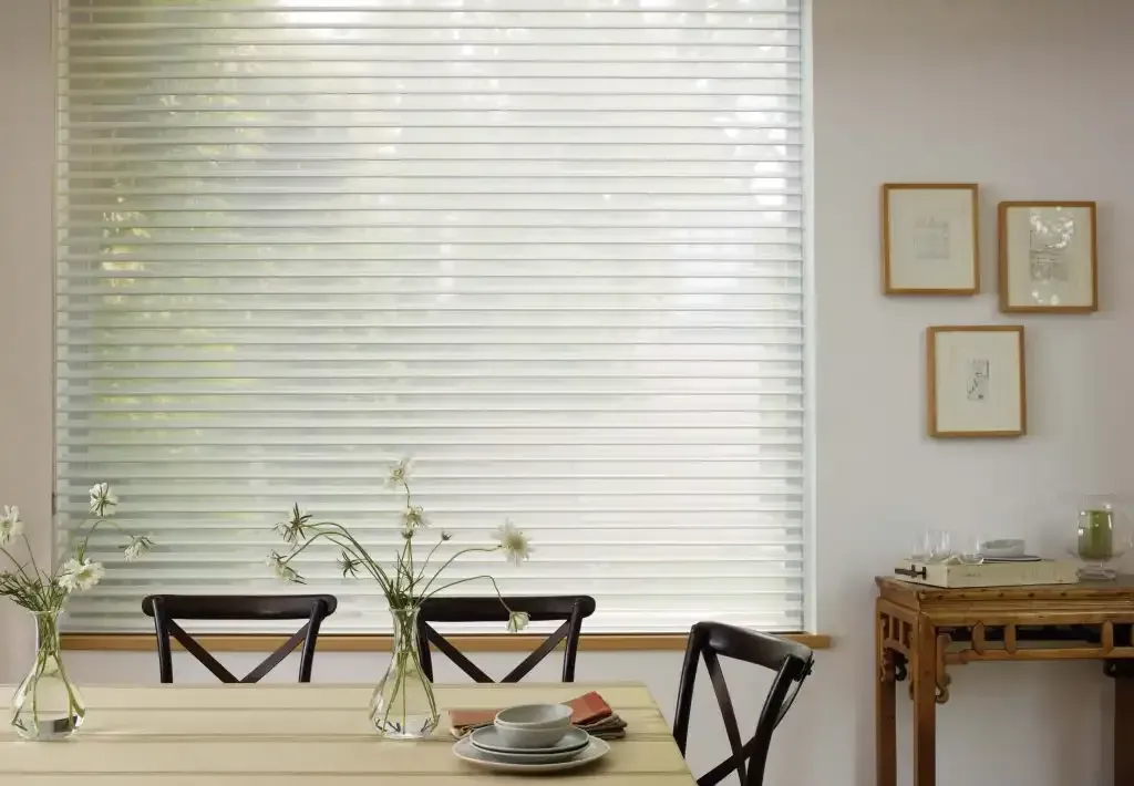 Dining room with table set for a meal, large window with blinds, artwork, and a small table.