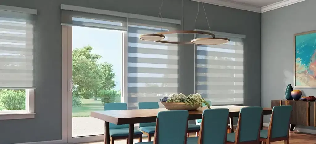 Dining room with a table, chairs, large windows with blinds, and artwork on the wall.